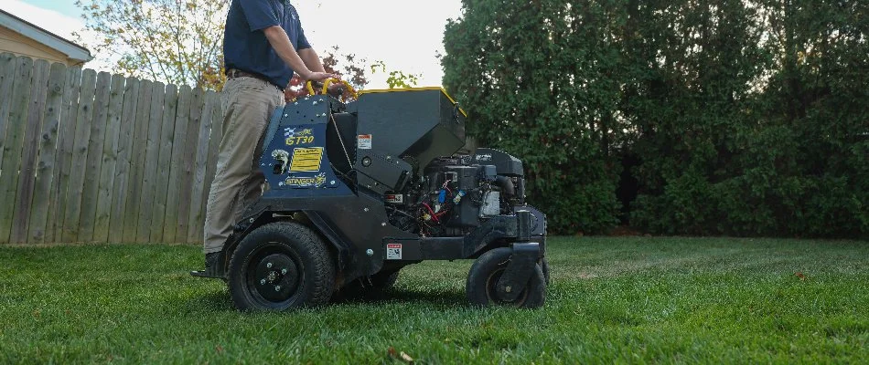 Worker using an aerator machine on a lawn in Doylestown, PA.