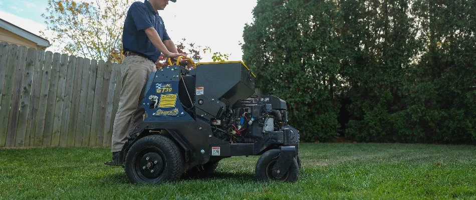 Worker aerating a lawn in Lansdale, PA, with an aerator machine.